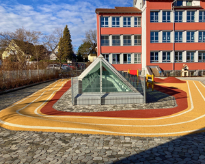 Blick auf ein pyramidenartiges Spielgerät auf dem Pausenhof.