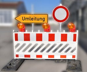 Rot-weiße Absperrung mit Umleitungsschild.
