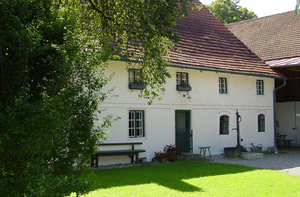 Bauernhof aus dem 18. Jahrhundert mit grasbewachsenem Innenhof und Scheune