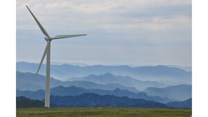 Weißes Windrad in der Landschaft.