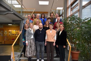 Gruppenfoto: 11 Frauen und 6 Männer stehen auf einer Treppe