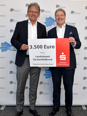 Zwei Männer halten ein Plakat mit der Aufschrift 3500 Euro.