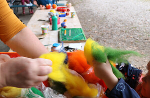 Zwei Kinderhände halten bunte Filzstücke