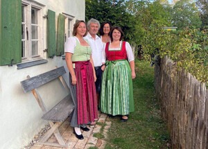 Musikanten in Tracht stehen vor einem Haus.