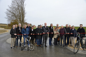 Gruppenfoto 4 Frauen und 15 Männer, jeder mit Schere in der Hand, durchschneiden rotes Band.