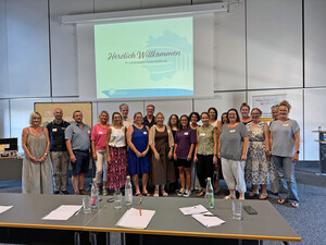 Teilnehmerinnen und Teilnehmer der Arbeitsgemeinschaft der Sozial- und  Pflegedienste stehen im Großen Sitzungssaal.
