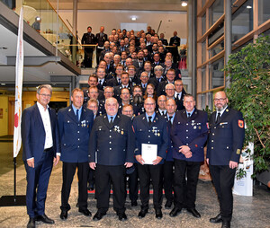 Gruppenfoto mit 75 Feuerwehrleuten auf einer großen Treppe