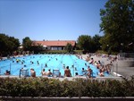 Badegäste sitzen am Beckenrand.